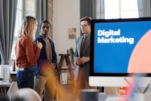 Group of colleagues discussing digital marketing strategies in an office setting.